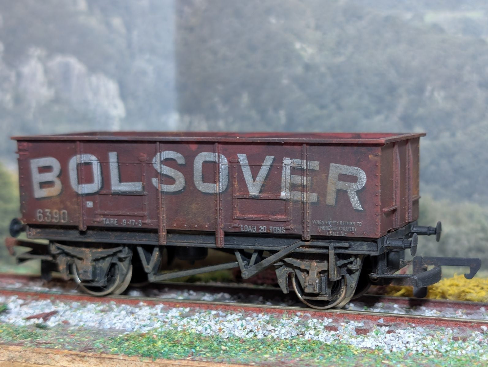Model railway wagon with 'Bolsover' branding on a track with a scenic background.